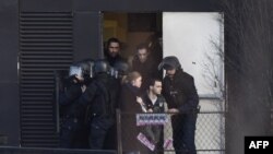 Полицейские эвакуируют жителей в районе Порт-де-Винсенн. Париж, 9 января 2015 года. 