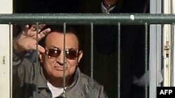 Бывший президент Египта Хосни Мубарак машет своим сторонникам с балкона военного госпиталя в Каире. Ноябрь 2014 года.