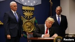 U.S. President Donald Trump signing his temporary ban on refugees earlier this year