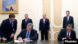 Armenia - Transport Minister Gagik Beglarian (R) and Georgian Deputy Prime Minister Giorgi Kvirikashvili sign an agreement to build a new bridge on the Armenian-Georgian border, Yerevan, 24Dec2014.