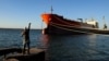  A man fishes near a Cuban-flagged docked at the Matanzas terminal, where a Russian oil tanker was to offload, on February 10.