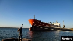 A man fishes near a Cuban-flagged docked at the Matanzas terminal, where a Russian oil tanker is likely to offload.
