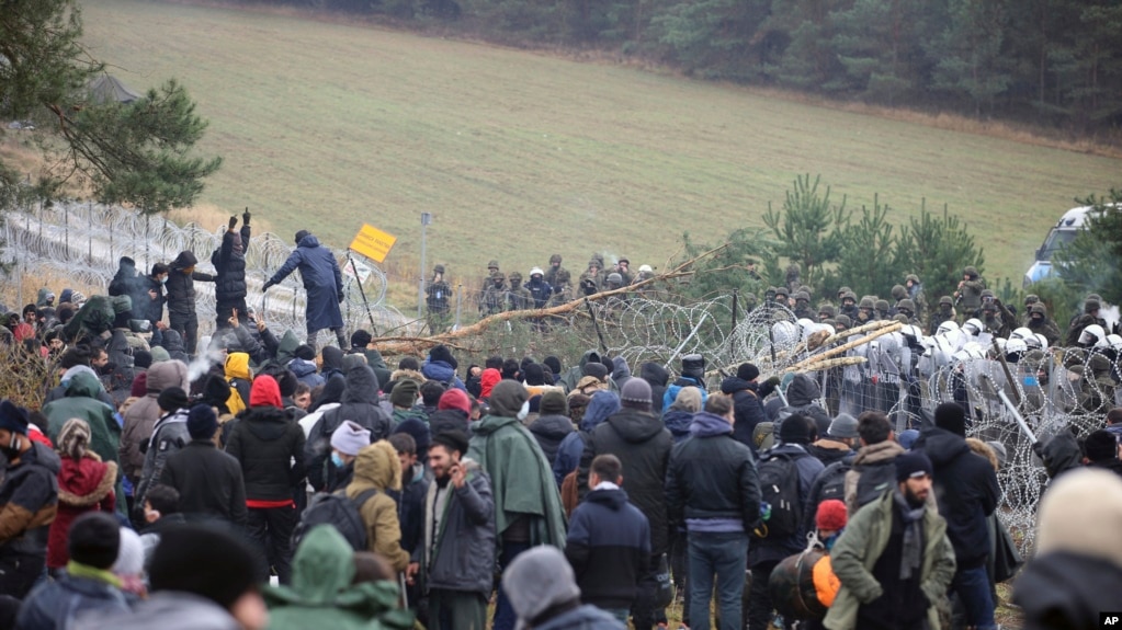 Мигранты штурмуют забор на границе Польши и Беларуси с белорусской стороны. Район Гродно, 8 ноября 2021 года
