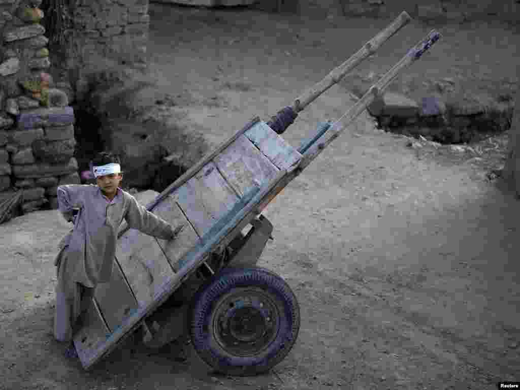 Nine-year-old Murad Khan leans on a cart while standing outside his home in the outskirts of Islamabad. Photo by Faisal Mahmood (Reuters)