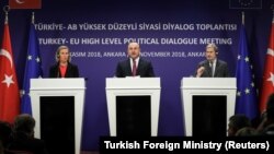 Високата претставничка за надворешна политика Федерика Могерини, шефот на турската дипломатија Мевлут Чавушоглу и еврокомесарот за проширување Јоханес Хан.