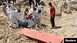 Луѓето ги носат телата на Палестинците убиени за време на израелската воена офанзива и закопани во болницата Насер, во Кан Јунис во јужниот дел на Појасот Газа, 21 април 2024 