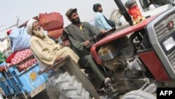 Displaced families fleeing their village in Marjah arrive in Lashkar Gah in Helmand Province on February 8.