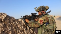 An Afghan soldier takes position during a military operation in Helmand province on August 12.