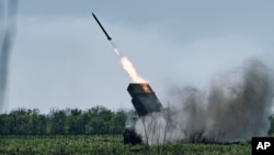 Un lansator de rachete multiplă ucraineană Grad trage rachete asupra pozițiilor rusești de pe linia frontului, lângă Bahmut, în regiunea Donețk.