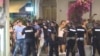 Pristalice SNS-a iza kordona policije za vreme napada na građane, Bačka Palanka, 12. avgust 2025.