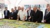 Belrusian President Alyaksandr Lukashenka (center) visits the Belarusian Biotechnological Corporation on August 10 with a man (holding the pointer) who looks like Kyrgyzstan's wanted former prime minister, Daniyar Usenov.