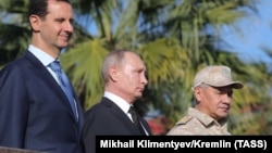 Syrian President Bashar al-Assad (left), Russian President Vladimir Putin (center), and Russian Defense Minister Sergei Shoigu visit the Hmeimim military base in Latakia Province on December 11.