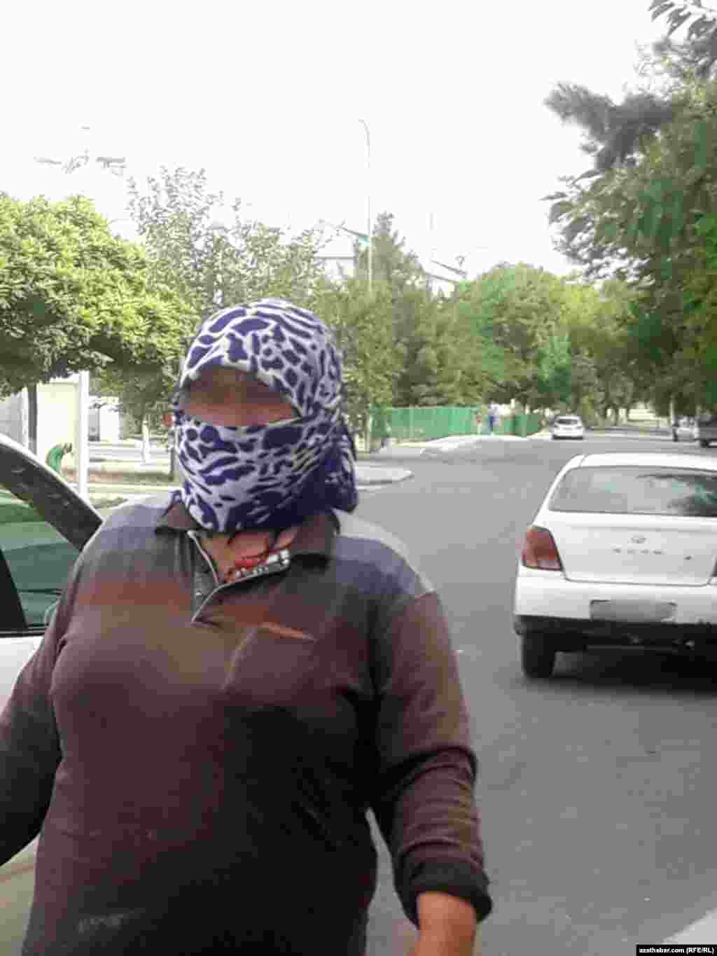 Aşgabat. &quot;Zyýanly tozanjyklar&quot; zerarly ýüz maskasyny geýmeli bolan aýal. Awgust, 2020.