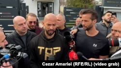 The Tate brothers, Tristan and Andrew, talking to press in front of the police station in Voluntari, Romania, on March 24.