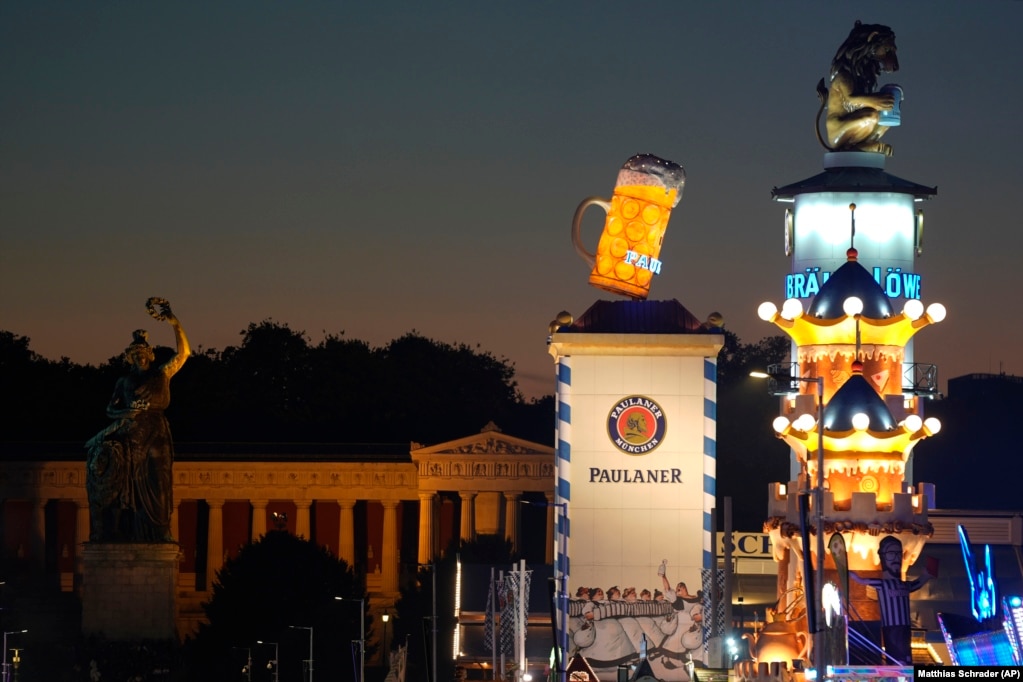 Një Luan në pije, nuska e fabrikës së birrës Loewenbraeu, e vendosur në çati, krahas një gote gjigante birre, logoja e fabrikës së birrës Paulaner, në ditën e hapjes së edicionit të 189-të të festivalit të birrës Oktoberfest në Munih.