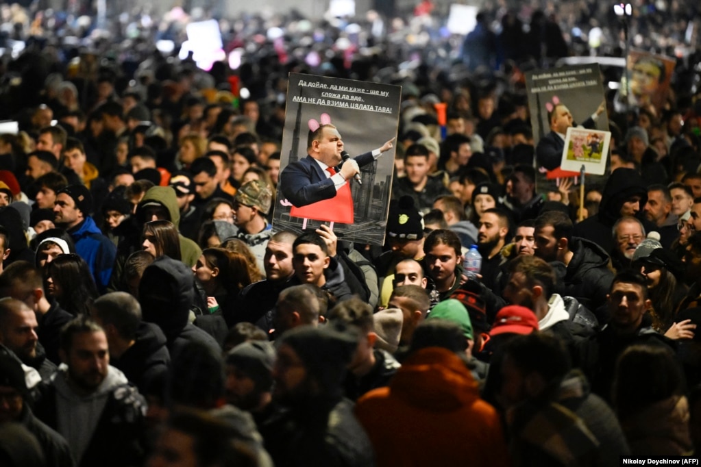 Protestuesit me një pllakatë të politikanit bullgar, Delyan Peevski gjatë protestave në Sofje. Kjo figurë politike bullgare është e sanksionuar nga Shtetet e Bashkuara dhe Mbretëria e Bashkuar, nën dyshimet për korrupsion.