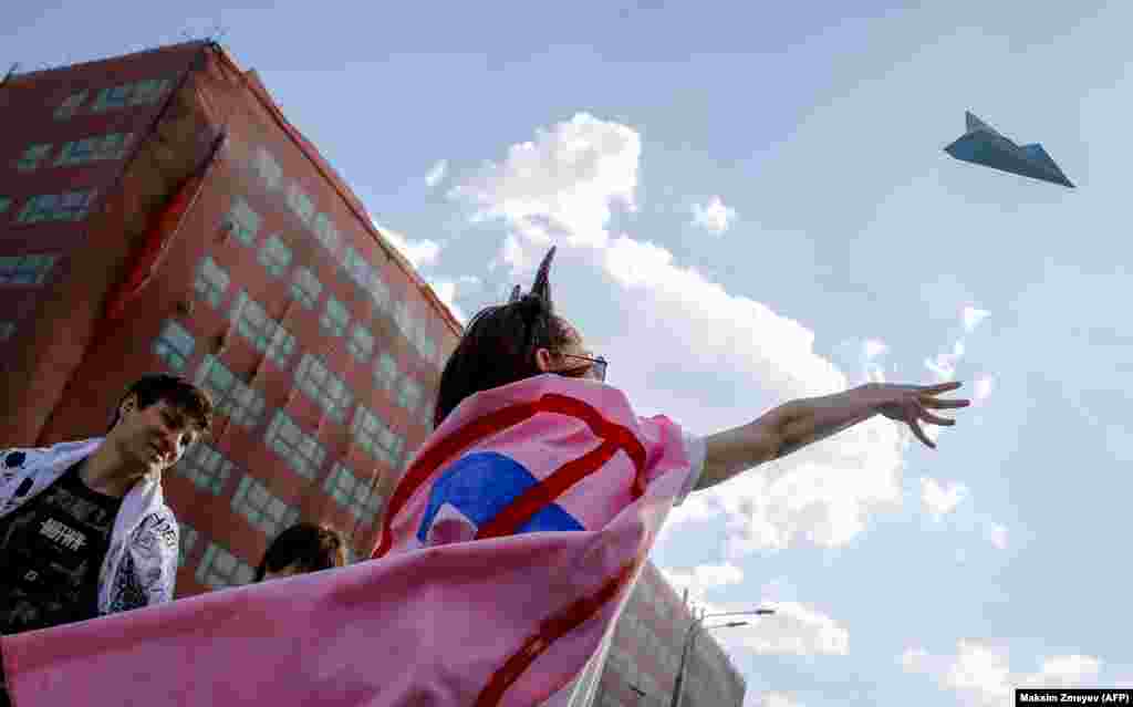 A woman releases a paper plane, symbol of the Telegram messenging service, during a rally to demand Internet freedom in central Moscow on May 13. (AFP/Maksim Zmeyev)