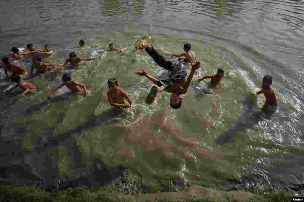 Pakistan - Temperatura u Peshawaru je dosegla 38 stupnjeva Celsiusa, a ovi dječaci su našli način kako je bolje podnijeti, 9. maj 2012. Foto: Reuters / Fayaz Aziz 