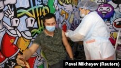 Коронавирусқа қарсы вакцина салдырып отырған адам. Алматы, 27 сәуір 2021 жыл.