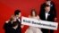 Russian actress Irina Starshenbaum (center) and other cast members hold a sign with the name of Russian director Kirill Serebrennikov as they arrive for the screening of his film Leto in Cannes.