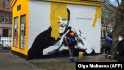 A worker paints over the mural of jailed Kremlin critic Aleksei Navalny in St. Petersburg.