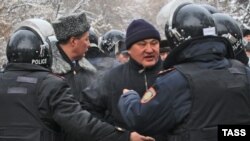 Kazakh police try to pacify protesters in Almaty who were rallying against measures taken by the authorities to suppress demonstrations in the oil town of Zhanaozen. At least 16 people were killed in violent clashes between police and demonstrators.