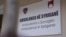 Një tabelë e sapovendosur në ndërtesën e ambulancës në fshatin Syriganë të Skenderajt, tani mban emrin "Ambulanca në Syriganë" në tri gjuhë: shqip, serbisht dhe anglisht, 15 prill 2026.