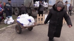 Єврокомісар взяв участь у роздачі гуманітарних наборів на Донбасі (відео)