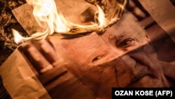 A poster picturing U.S.-based preacher Fethullah Gulen burning during a Pro-Erdogan supporters rally in Istanbul on July 18.