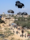 Palestinski dječak trči dok se pomoć iz zraka spušta padobranom na zemlju u Deir Al-Balahu, Gaza, 12. avgusta 2025.