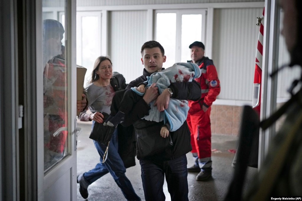 Maryna Yatsko duke vrapuar në një spital pas të dashurit të saj, Fedir, që është duke mbajtur  djalin e saj 18 muajsh, Kyrylo, i cili u godit gjatë bombardimeve të Mariupolit më 4 mars 2022. Kyrylo nuk mbijetoi.