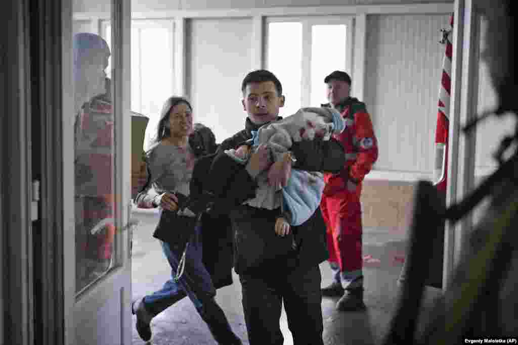 Maryna Yatsko (left) and her boyfriend, Fedir, run into a Mariupol hospital carrying Yatsko&#39;s injured 18 month-old son, Kyrylo, on March 4.&nbsp;