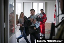 Мариуполь в блокаде. Раненого 4-летнего мальчика заносят в больницу. Его не удалось спасти. Фото и видео о жизни блокадного города мир узнавал, в основном, от журналистов AP Евгения Малолетки и Мстислава Чернова