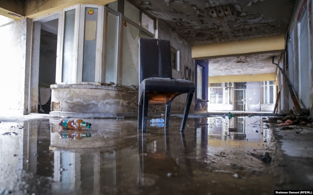 Kështu duket brendësia e një ndërtese në Prishtinë, e lënë pas dore. Aty shihet një karrige, teksa dyshemeja është e mbuluar me ujë.
