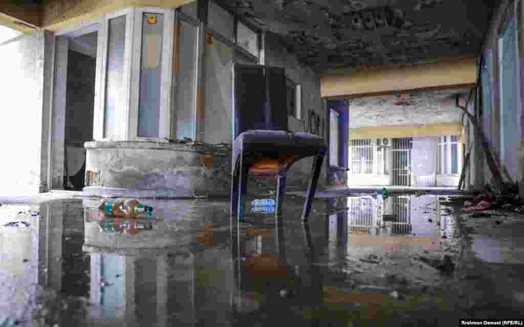 Kështu duket brendësia e një ndërtese në Prishtinë, e lënë pas dore. Aty shihet një karrige, teksa dyshemeja është e mbuluar me ujë.