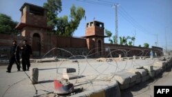 Pedestrians walk past the jail where Pakistani physician Shakil Afridi is being held after he was sentenced to 33 years in prison for helping U.S. forces kill Osama bin Laden.