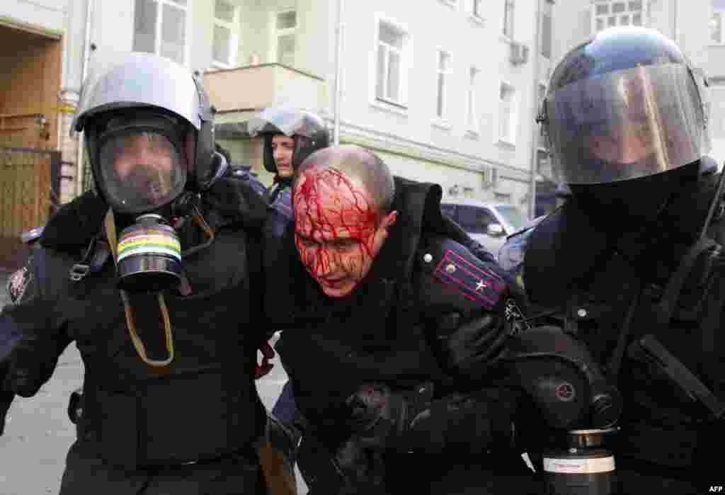 Policeman help a wounded colleague.