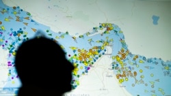 A large screen displaying vessel movements in the Strait of Hormuz on a ship-tracking website.