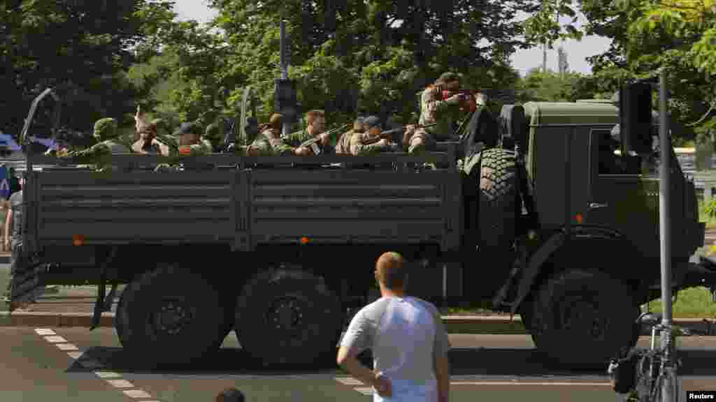 A military truck with heavily armed pro-Russian militants drives through a police checkpoint toward the airport of the eastern city of Donetsk.