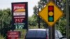 In this photo taken Thursday, June 14, 2018 an automobile drives past signage displaying gas prices at a Pilot gas station near Graham, N.C. 