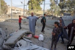 Un palestinian este nemulțumit deoarece cortul său de refugiat a fost avariat în urma atacurilor aeriene israeliene asupra unei clădiri cu șase etaje din cartierul Saftawi, la vest de Jabalia, în nordul Fâșiei Gaza, pe 19 august 2025.