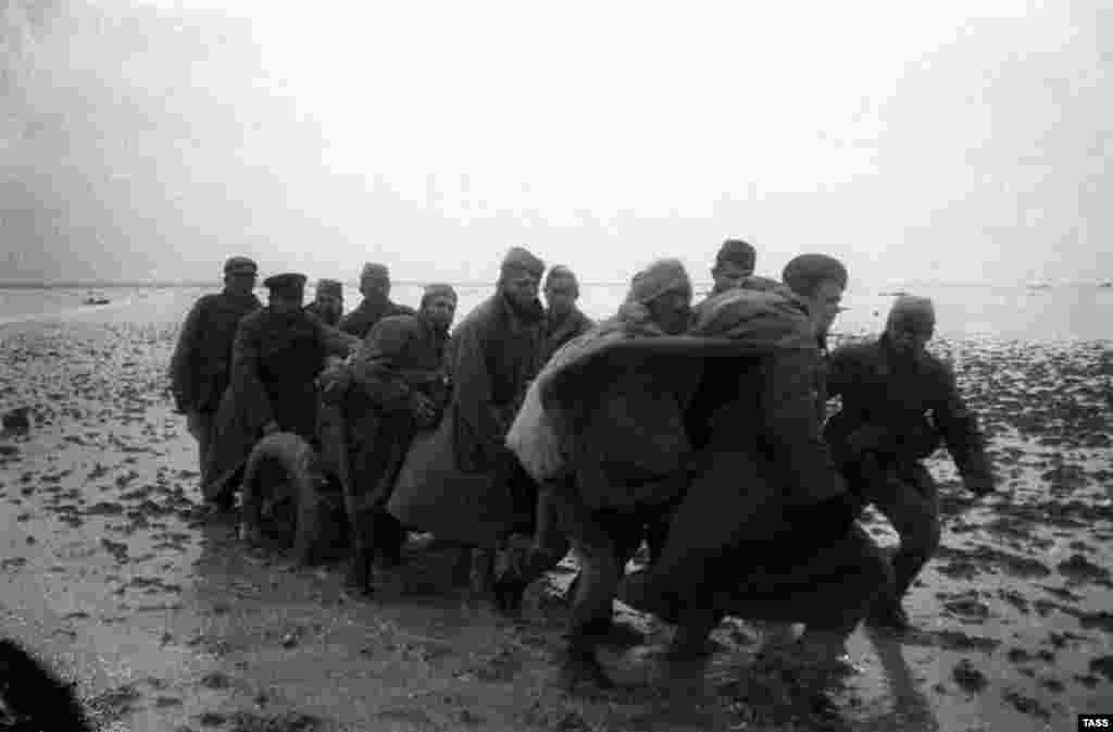 After the German defeat at Stalingrad in February 1943, the tide on the Soviet-German front began to shift. In late 1943, the Soviets prepared to retake Crimea by a combined assault across the Kerch Strait and down the Perekop Isthmus. The Soviets forced German prisoners of war to build walkways through the shallow Syvash Sea to enable Red Army forces to support the attack on the isthmus. By April 1944, the Germans had been pushed back into Sevastopol and the Red Army began its assault on the port. (Soviet soldiers crossing the Syvash Sea into Crimea in late 1943)