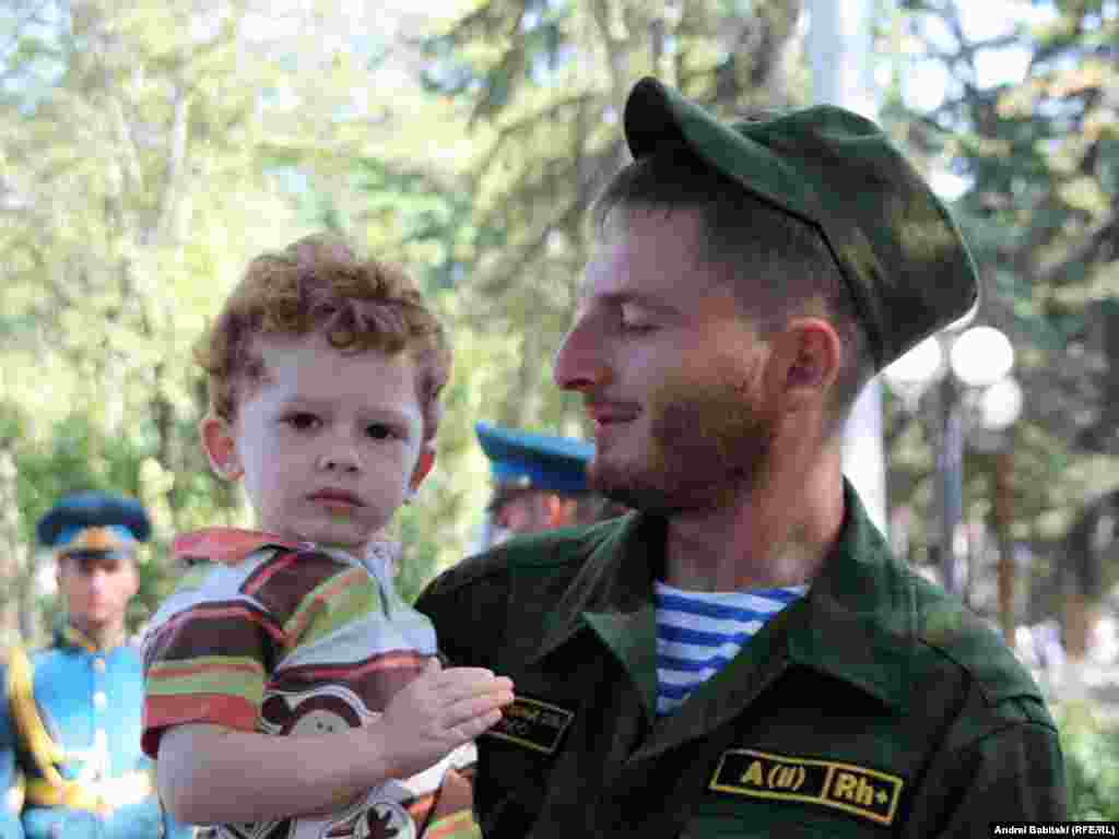 Солдат держит ребенка на руках во время праздничных мероприятий в Цхинвали - 20 сентября в Цхинвали прошел военный парад, посвященный празднованию Дня независимости самопровозглашенной республики Южная Осетия.
