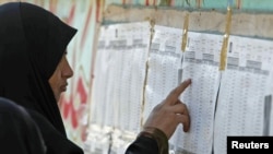 A woman checks candidate lists for the March 7 parliamentary elections at a polling station in Al-Basrah on March 3.