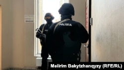 Полицейский спецназ у дверей редакции Orda.kz, внутри которой проходит обыск после возбуждения дела в отношении главреда издания Гульнары Бажкеновой по статье «Распространение заведомо ложной информации»