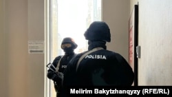 Orda.kz редакциясы есігінің сыртында тұрған қарулы полиция. Алматы, 1 желтоқсан, 2025 жыл.