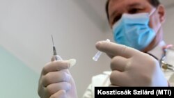 Szlávik János infektológus főorvos egy Pfizer és a BioNTech által kifejlesztett koronavírus elleni oltóanyaggal a Dél-pesti Centrumkórházban 2020. december 26-án.