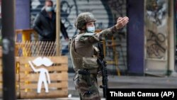 A French soldier attends the scene of a knife attack near the former offices of satirical newspaper Charlie Hebdo in Paris on September 25.