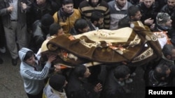 Syrian antigovernment protesters on January 29 carry a body during the funeral of a protester killed in earlier clashes in Baba Amro.
