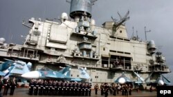 Russian naval personnel stand in front of the aircraft carrier Kuznetsov in Syria's Mediterranean port of Tartus in 2012.